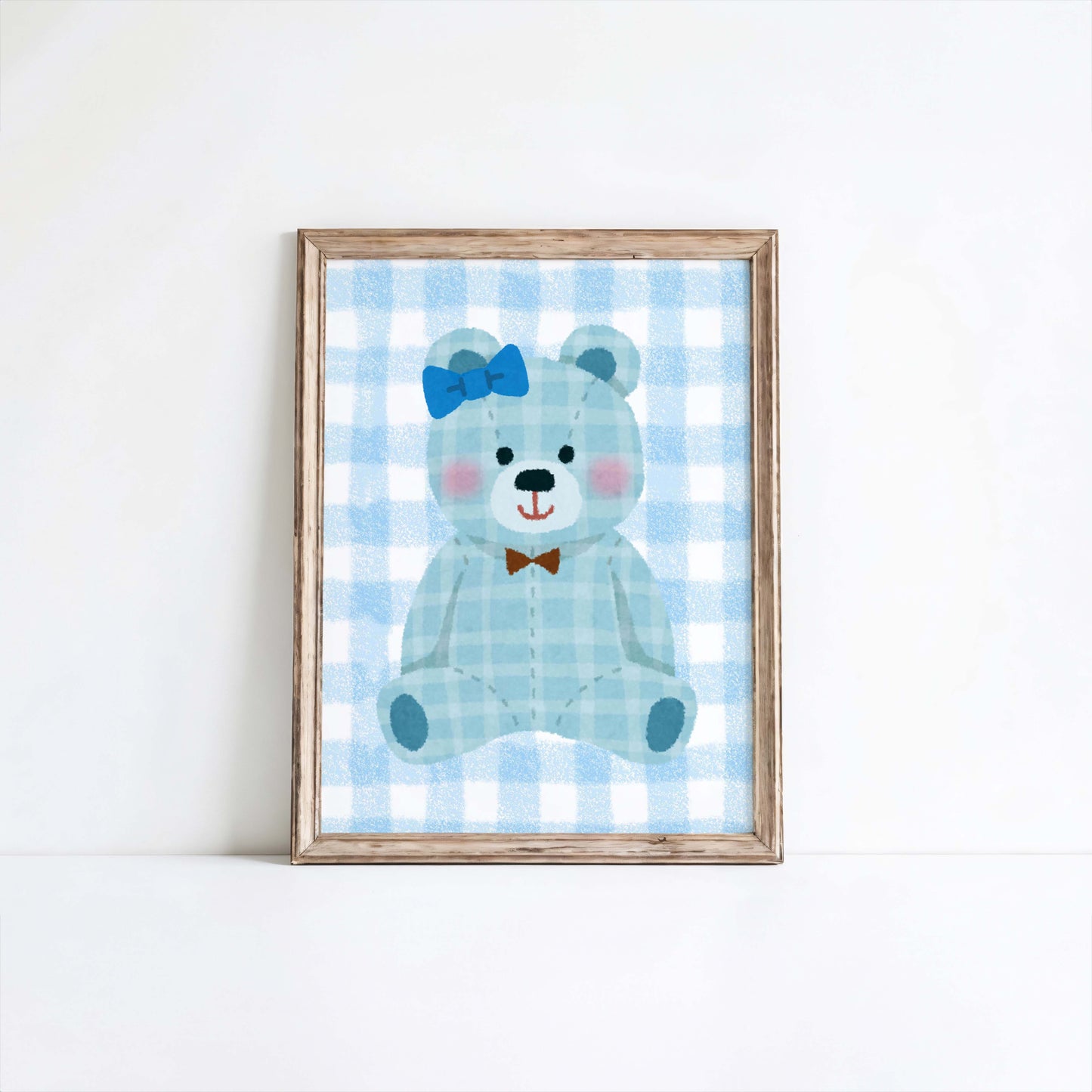 Blue gingham teddy bear nursery wall art print in a wooden frame, perfect for baby boy room decor. Features a cute teddy with a blue bow and a brown bow tie on a checkered background.