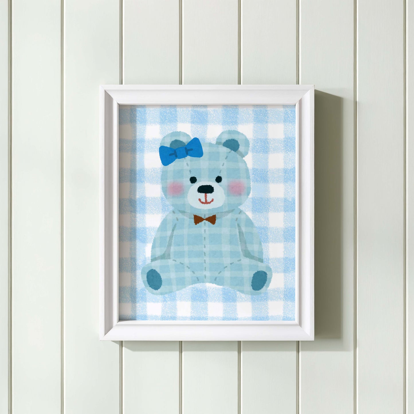Blue gingham teddy bear nursery wall art print in a wooden frame, perfect for baby boy room decor. Features a cute teddy with a blue bow and a brown bow tie on a checkered background.
