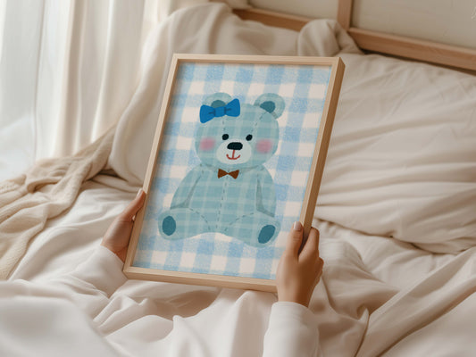 Blue gingham teddy bear nursery wall art print in a wooden frame, perfect for baby boy room decor. Features a cute teddy with a blue bow and a brown bow tie on a checkered background.